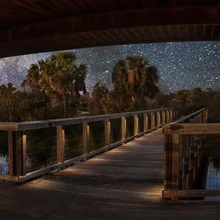 Photo of Black Rectangular Wedge Light Low Voltage - Side Post displayed on a wooden deck at night