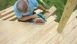 photo of man cutting deck-boards