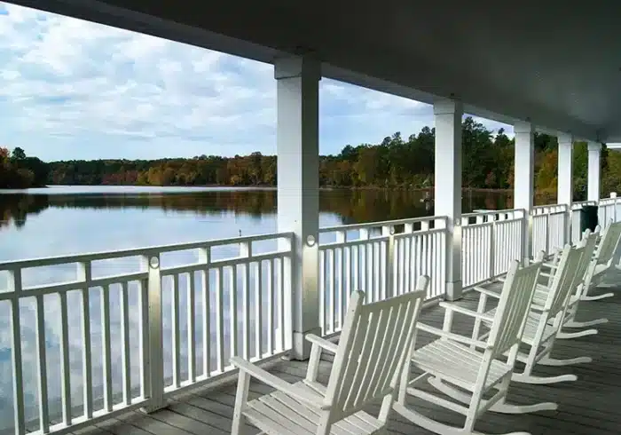 Photo of White Round Wedge Light Low Voltage - Side Post in white railing on a waterfront covered deck